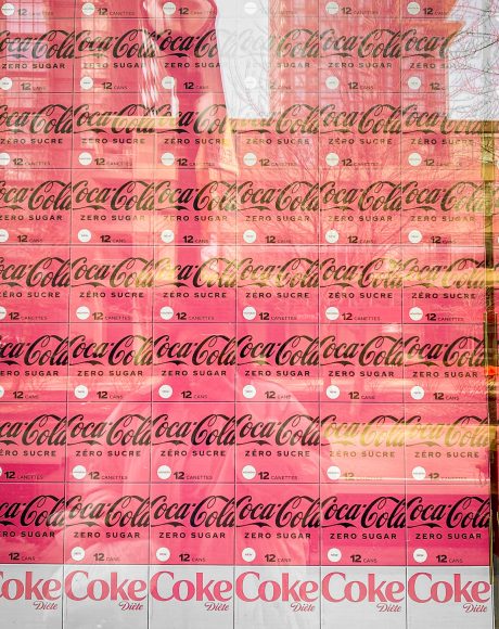 pink Coca Cola boxes stacked on top of each other inside a glass.